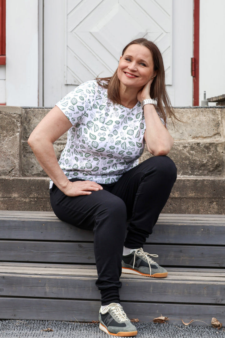 Jannika t-paita POP-kuosilla vihreällä painatuksella. Näyttelijä Karoliina Blackburnilla on puserosta koko M. Pusero on valmistettu Suomessa.