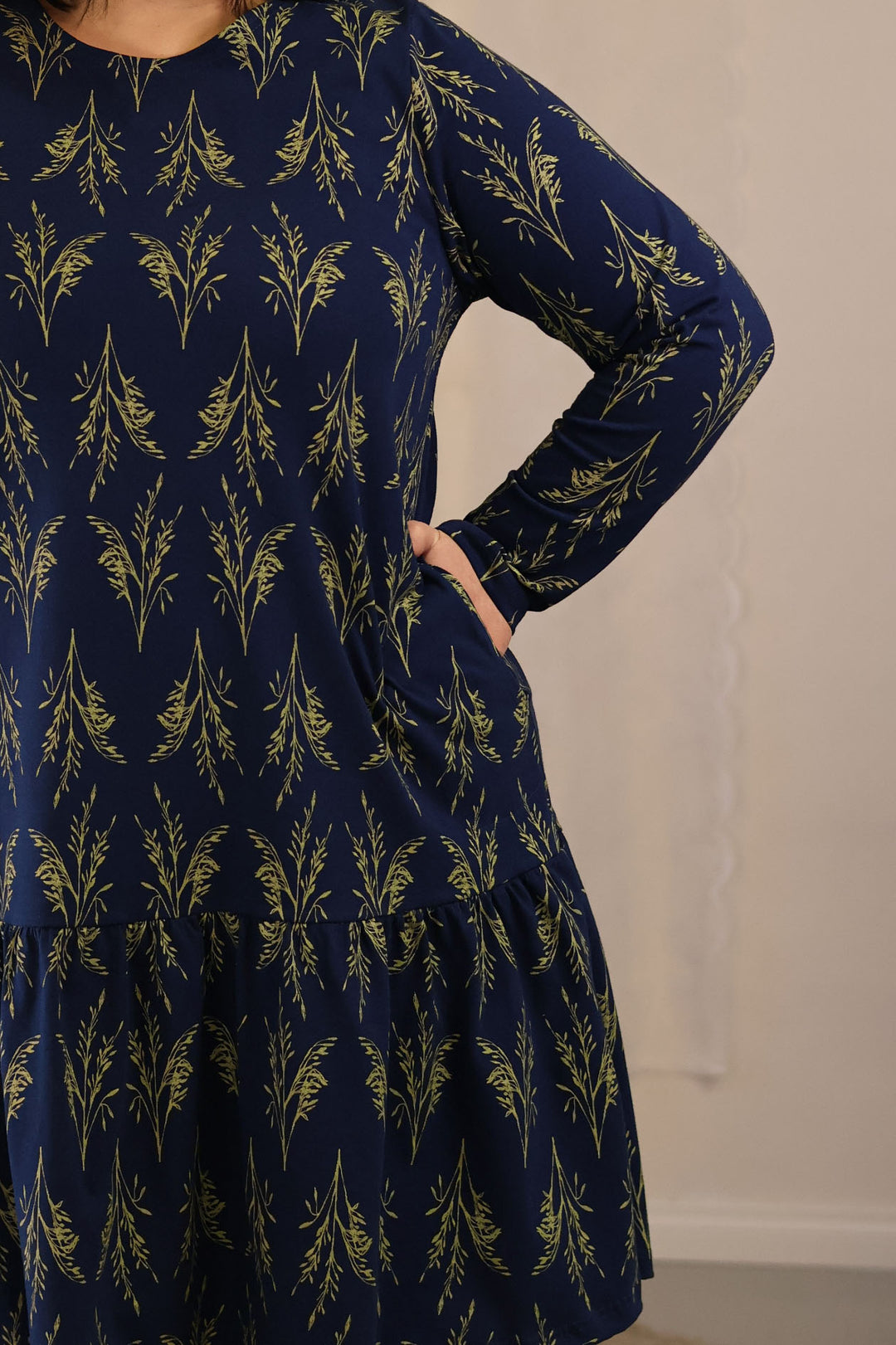 Lähikuva Juni-neulosmekosta. Mekossa on poimutettu helma sekä taskut.