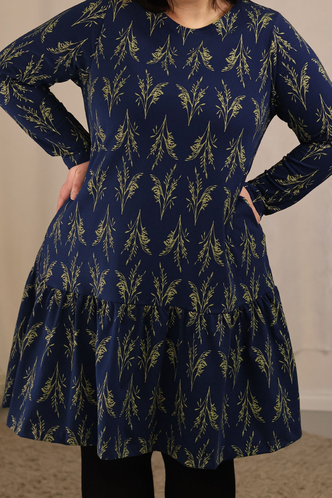 Lähikuva Juni-neulosmekosta. Kuvassa näkyy hyvin a-linjaisen mekon poimutettu helma. Mekossa on myös taskut. Mekko on valmistettu täysin Suomessa.