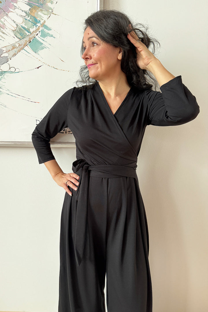 Lähikuva XS/S-kokoisesta ja mustasta Madeline- kietaisuhaalarista.