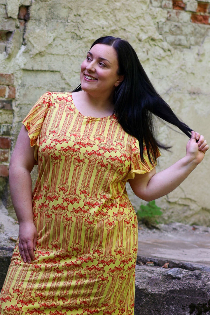 Miina-maxineulosmekko koossa XXL. Mekossa on upea keltainen väri, ja Amaryllis-kuosi on painettu punaisella värillä.