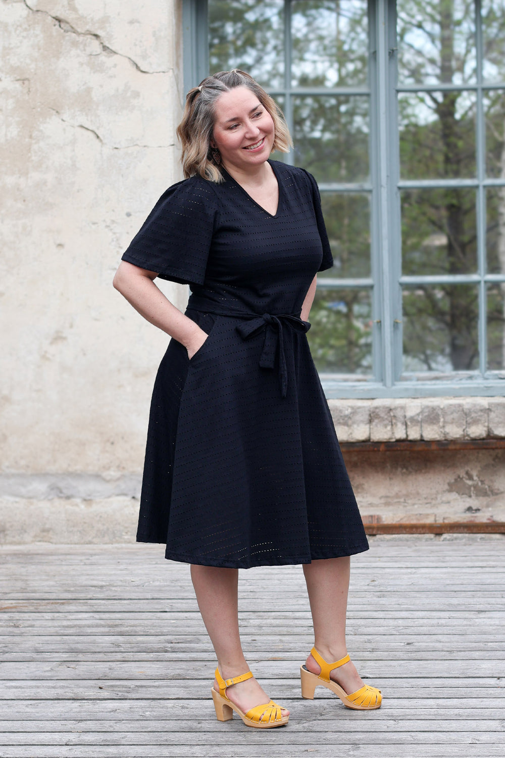 Sofie-neulosmekko reikäraita-materiaalilla koossa M. Tässä kotimaisessa ja juhlavassa mekossa on kauniit perhoshihat ja tietysti taskut.